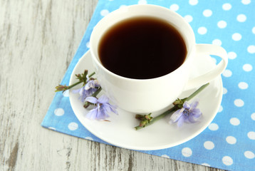 Cup of tea with chicory, on wooden background
