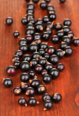 Fresh black currant on wooden background