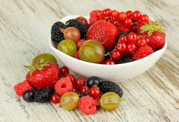Ripe berries in bowl on table close-up