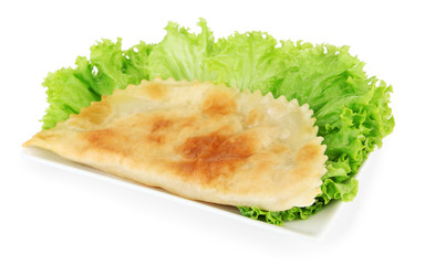 Tasty cheburek with fresh herbs on plate,isolated on white
