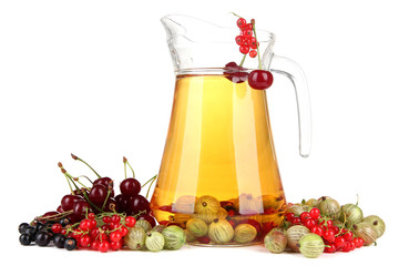 Glass pitcher of compote with different summer berries isolated