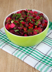 Beet salad in bowl on table close-up