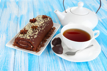 Sweet roll with cup of tea on table close-up