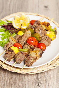 Hot roasted meat with onion, tomato and pepper on the skewer