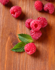 Ripe sweet raspberries on wooden background
