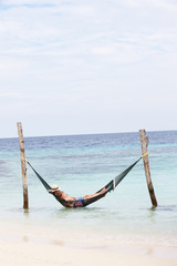 Grandfather And Grandson Relaxing In Beach Hammock