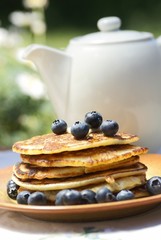 Stack of pancakes with blueberries and jug