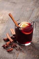 Mulled wine and spices on wooden background. Selective focus.