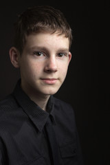 Obraz premium Portrait of a teenage boy against dark background