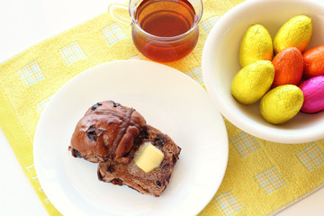 Fototapeta na wymiar Chocolate hot cross buns with butter and easter eggs