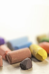 fragments of bright color pastels on white, low DOF