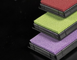 detailed view on colored stamping pads on black background