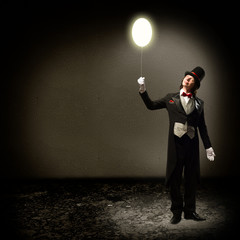 magician holding a glowing balloon