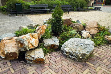Decorative rock-garden in city street with benches
