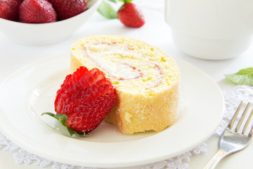 Biscuit roll with strawberry jam, and strawberries.