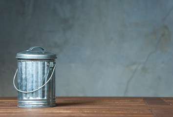 A zinc bin on the wooden table