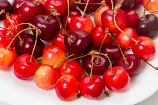 Ripe cherries  on a white plate