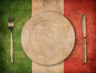 plate, fork and knife on grunge italian flag