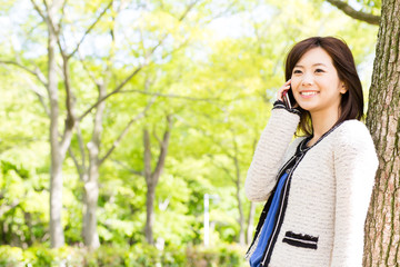 young asian woman talking in the park