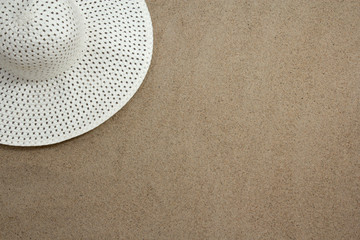 white female hat on sandy beach