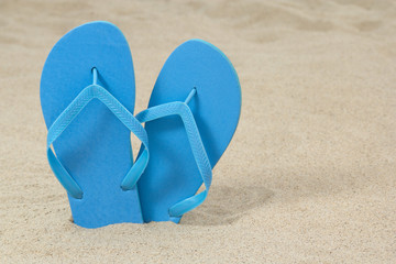 blue rubber flip flops on the sand