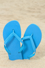 bright blue rubber flip flops on the sand