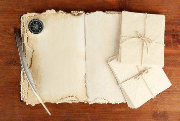 Open old book, letters and compass on wooden background © Africa Studio