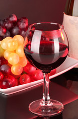 Glass of wine with lipstick imprint, grapes and bottle