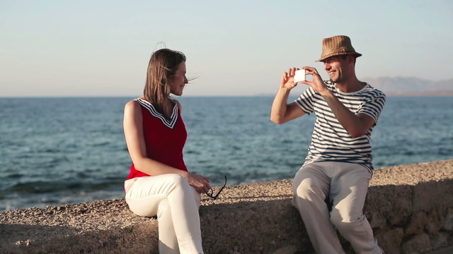 Couple taking photo with smartphone by the sea