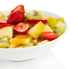 Useful fruit salad of fresh fruits and berries in bowl isolated