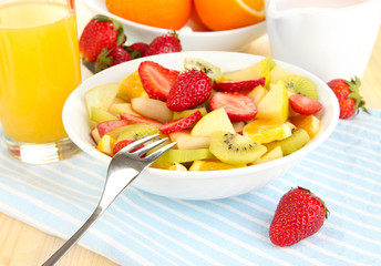 Naklejka na ściany i meble Useful fruit salad of fresh fruits and berries in bowl