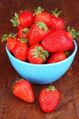 Fresh strawberry in bowl on wooden background