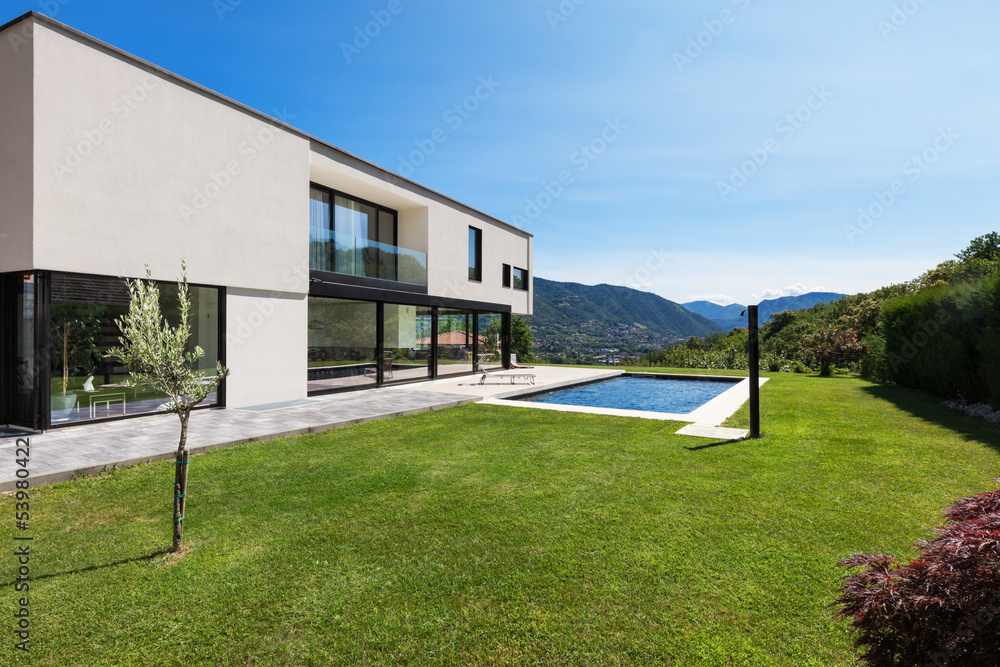 Wall mural Modern villa with pool, view from the garden