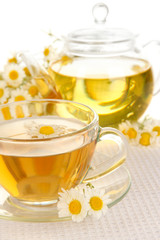 Cup of herbal tea with camomiles close up