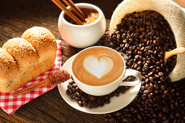 Fototapety  Filiżanka cafe latte z ziarnami kawy i chlebem