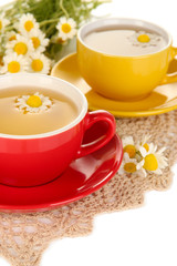 Cups of herbal tea with camomiles close up