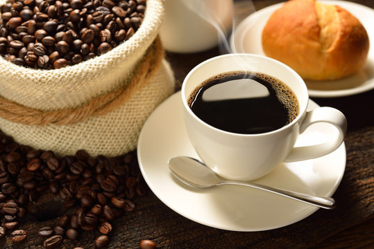 Coffee cup with a bread and fresh coffee beans