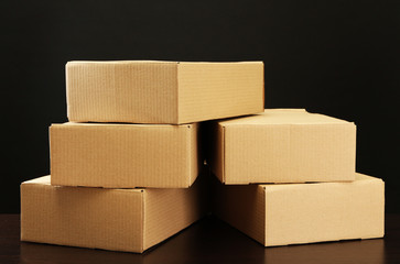 Parcels boxes on wooden table, on black background