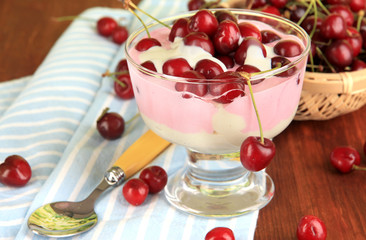 Delicious cherry dessert in glass vase on wooden table close-up