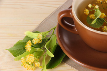 Cup of tea with linden on napkin   wooden table