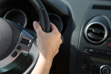 Hand am Lenkrad eines Autos