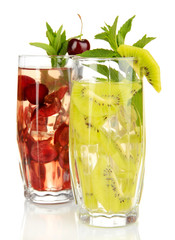 Glasses of fruit drinks with ice cubes isolated on white