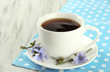 Cup of tea with chicory, on wooden background