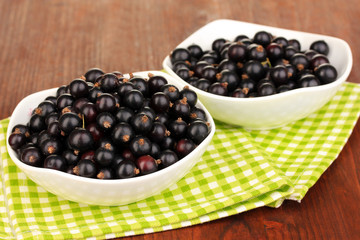 Fresh black currant on wooden background