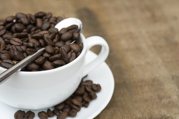 Cup of coffee and beans on wooden background