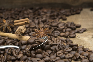 Coffee beans and spoon on wooden background