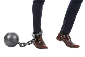 Business worker with ball and chain attached to foot isolated