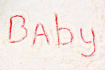 Word baby making with powdered milk on red background