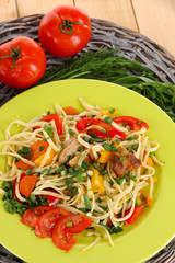 Noodles with vegetables on plates on wooden background