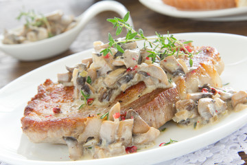 Pork steak with mushroom sauce and cream.